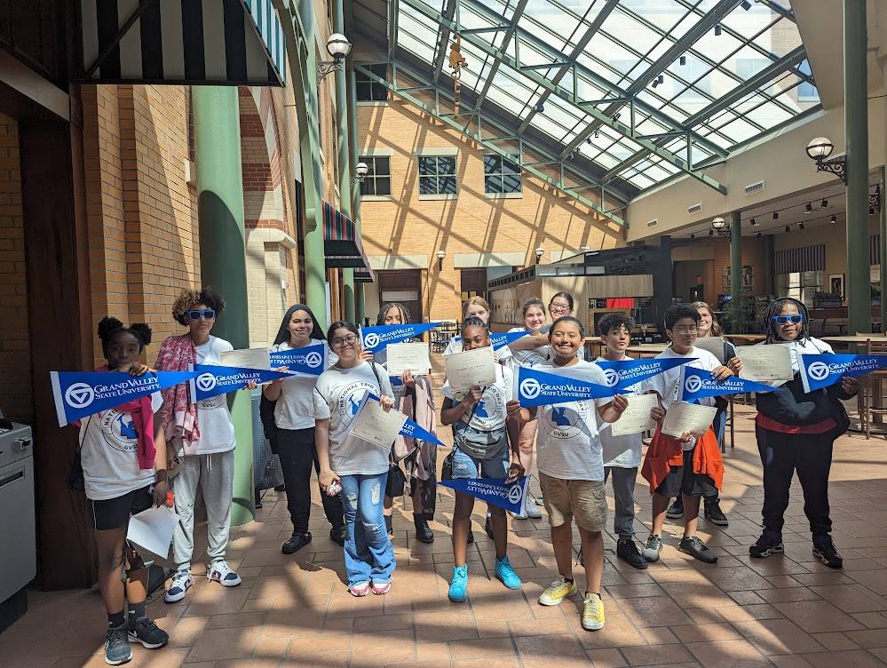 TRIO ETS students holding GVSU pennants